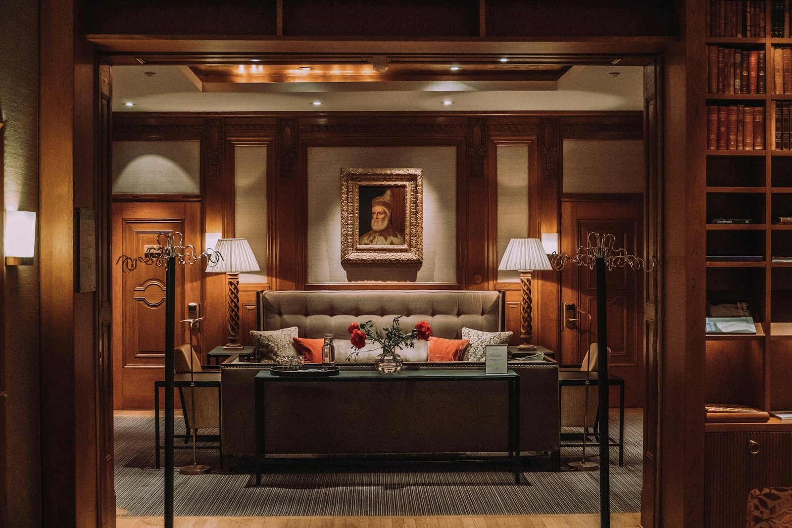 A warmly lit hotel lounge with timber panelling and inviting seating.